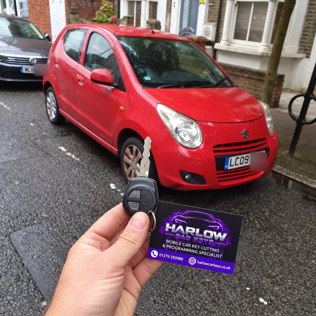 New key made for a 2009 Suzuki Alto in Bush Fair, Harlow after all keys were lost, held in front of the car with a Harlow Car Keys business card