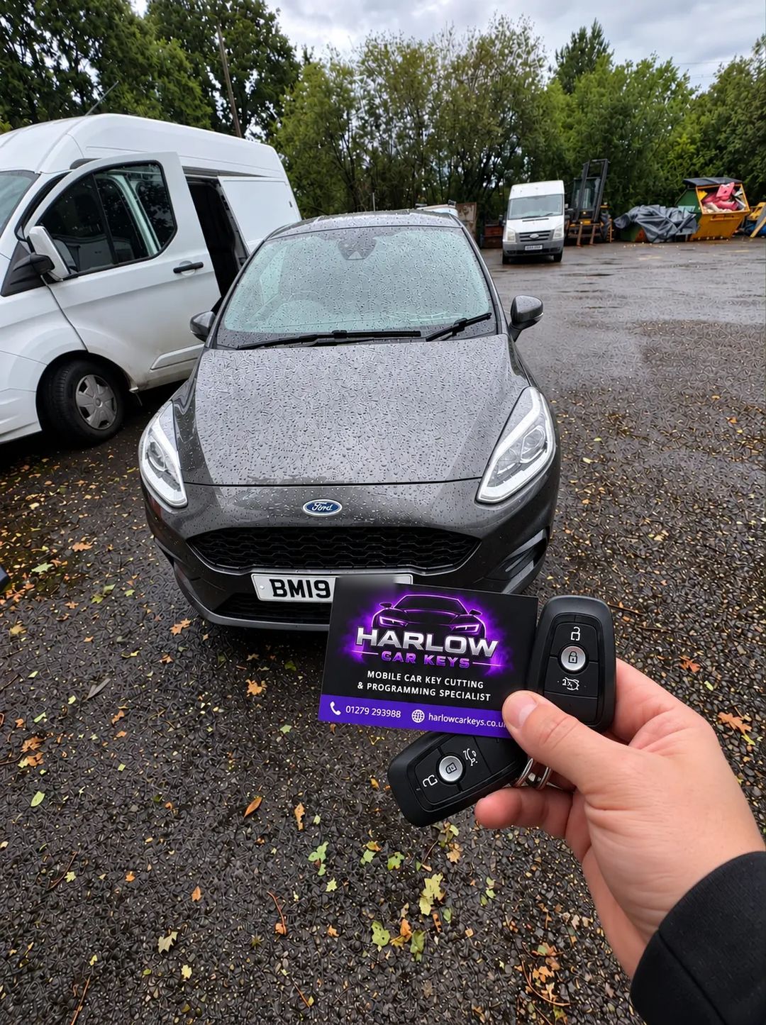 Two new keys supplied for a 2019 Ford Fiesta in Bishop's Stortford after all keys were lost, held in front of the car with a Harlow Car Keys business card