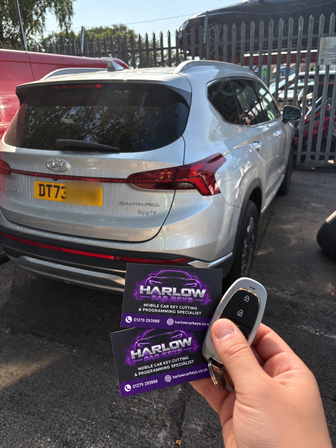 New key supplied for a 2023 Hyundai Santa Fe in Ware after the customer's keys were stolen, held in front of the car with Harlow Car Keys business cards