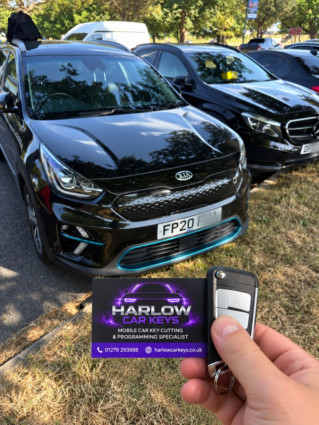 New key supplied for a 2020 Kia Niro in Potter Street, Harlow after all keys were lost, held in front of the car with a Harlow Car Keys business card