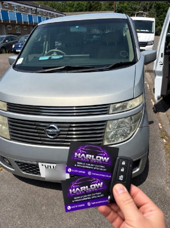 New key supplied for a 2003 Nissan Elgrand Japanese import in Sawbridgeworth, held in front of the vehicle with Harlow Car Keys business cards