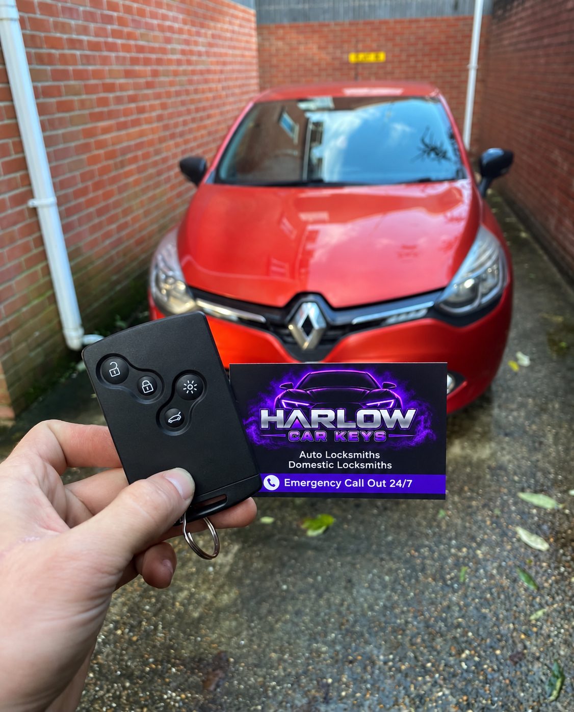 New key card supplied for a 2014 Renault Clio in Bishop's Stortford after the old key card was damaged, held in front of the car with a Harlow Car Keys business card